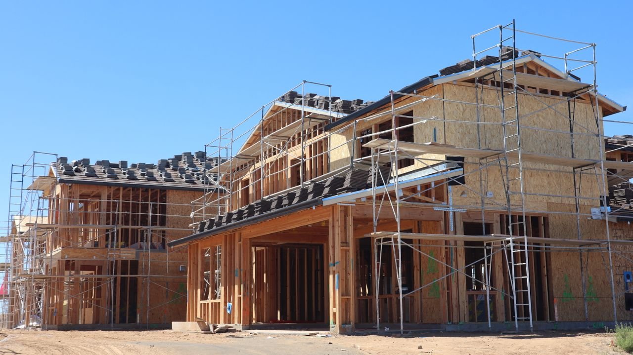 New residential homes under construction with scaffolding, showcasing modern architecture.